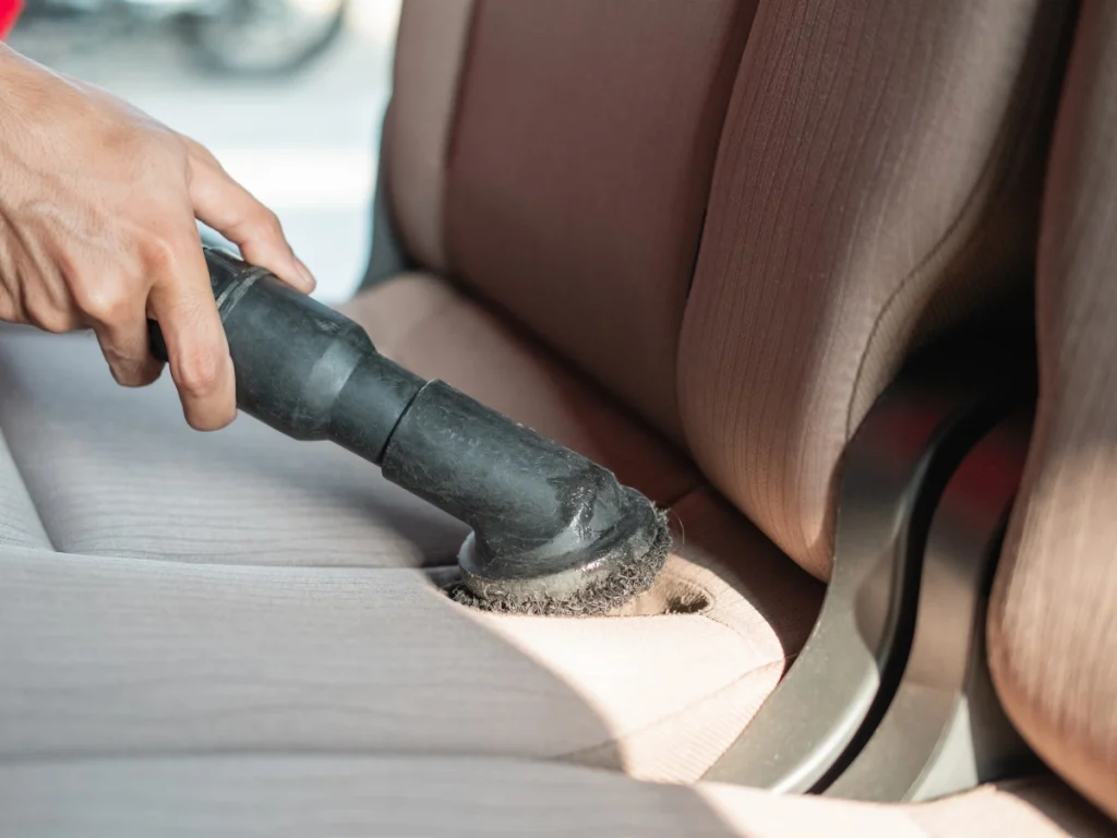 Westgreen Park Car Wash Service interior cleaning of a car seat with a vacuum cleaner by a professional.