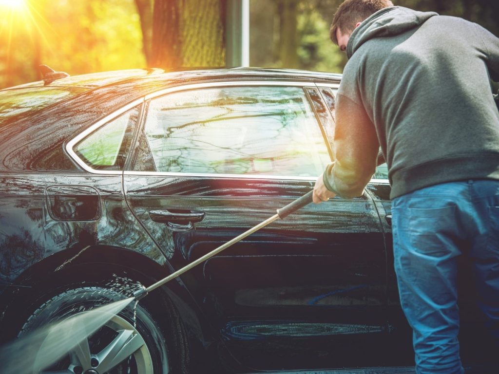 Man using a pressure washer to clean a car at a Best cheap car wash on Canyon Gate Cinco Ranch
