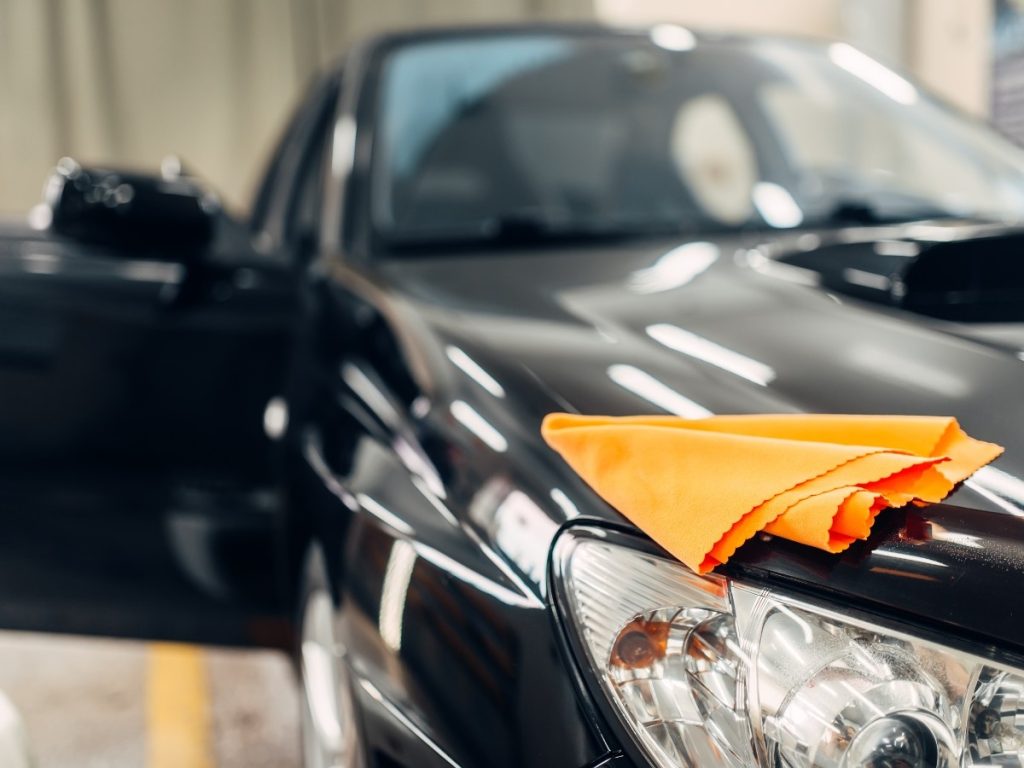 Unlimited monthly car wash membership in Cinco Ranch Equestrian Village, drying a clean car with a microfiber towel