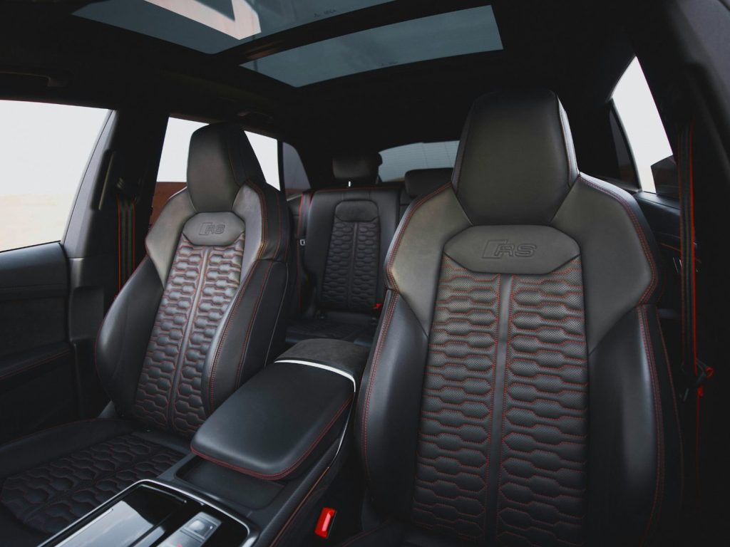 Luxurious black leather interior with red stitching of a car cleaned at Drive-Thru Car Wash Katy TX.