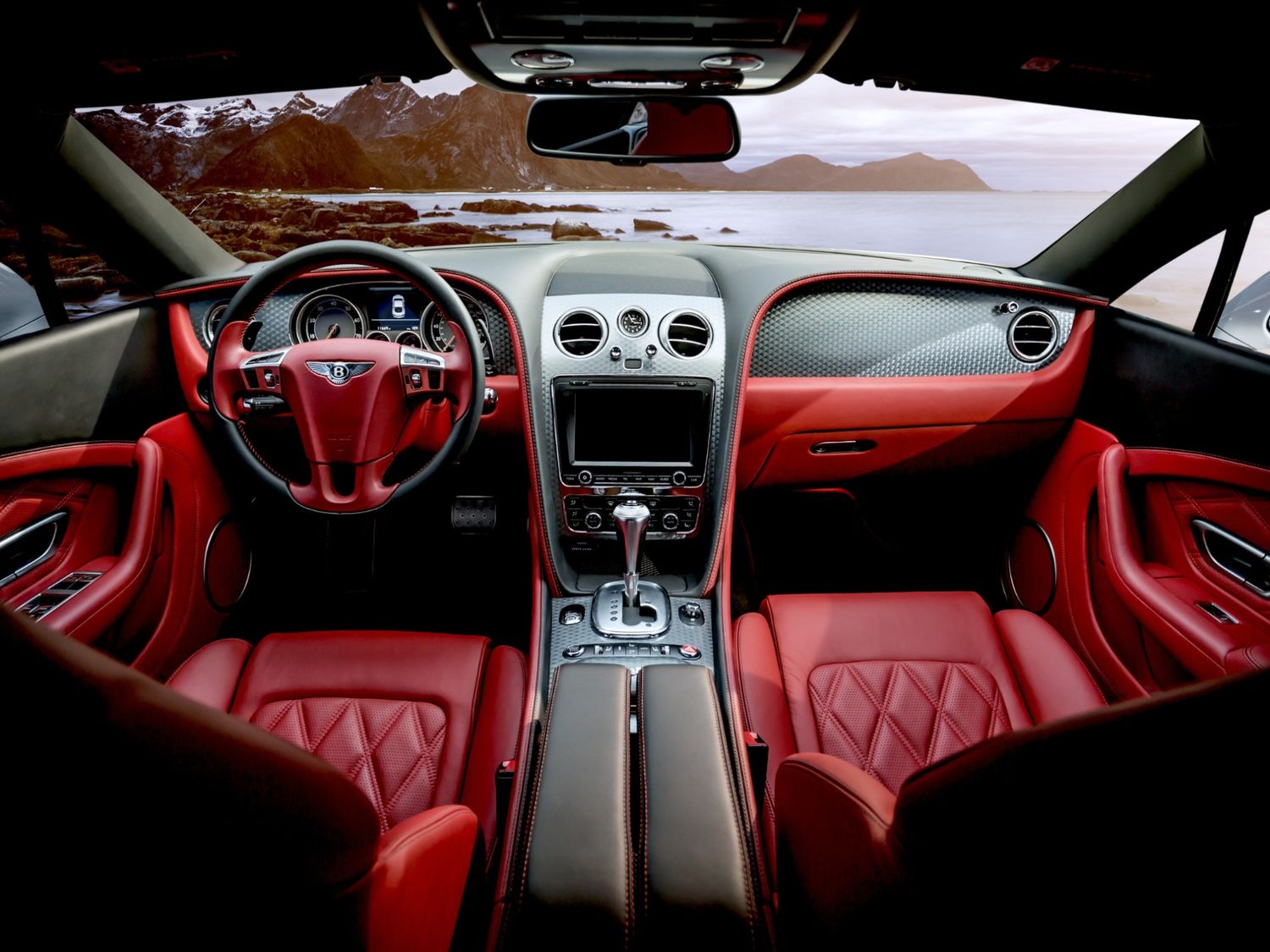 Luxury red leather Bentley interior with quilted seats and scenic ocean view, detailed at Drive-Thru Car Wash Katy TX.