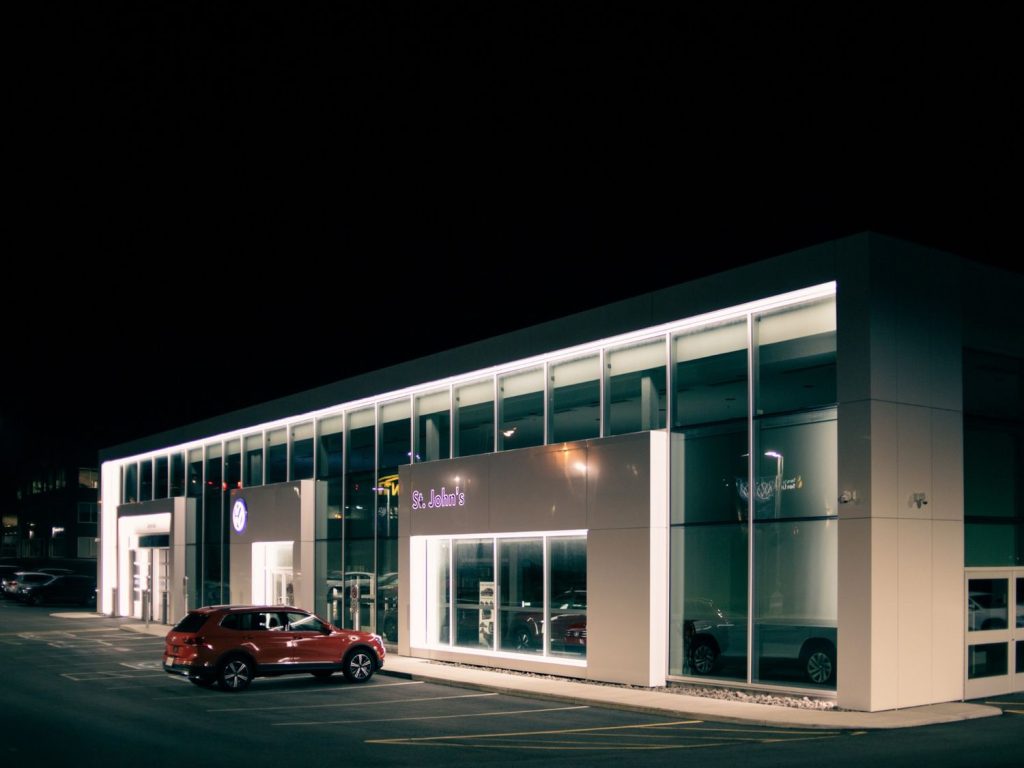 Closed sign on gate of Best Car Wash in Katy TX with dark night sky, showing closing time.