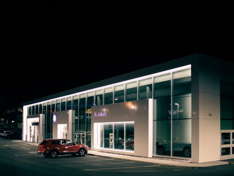 Closed sign on gate of Best Car Wash in Katy TX with dark night sky, showing closing time.