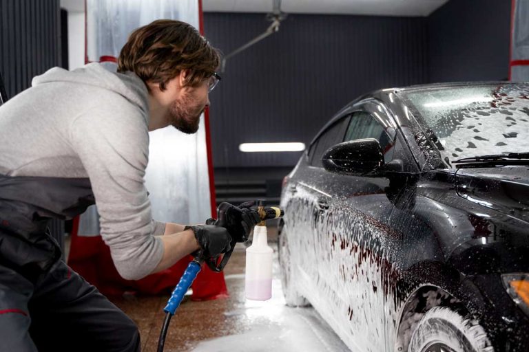 Unlimited car wash membership Katy TX offers expert foam wash service for spotless black car detailing in indoor facility.