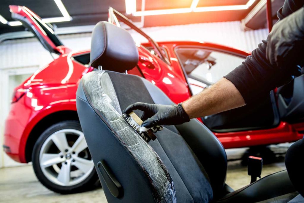 Best car wash membership Katy TX features interior detailing with brush and gloves for spotless upholstery and seat care.