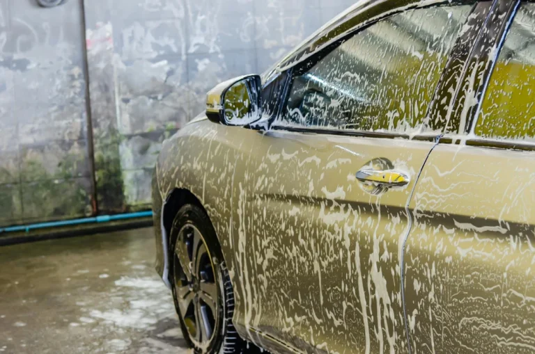 Gold-colored sedan covered in soap and foam during a thorough cleaning session for the Best Car Wash in Katy TX.
