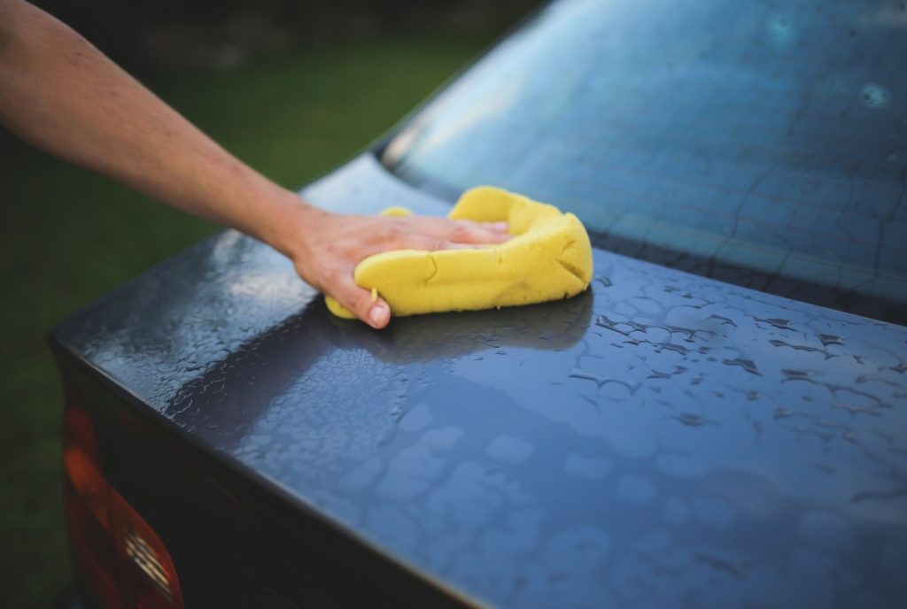 Washing car trunk using a sponge. Get a high-quality Affordable Car Wash Katy TX.