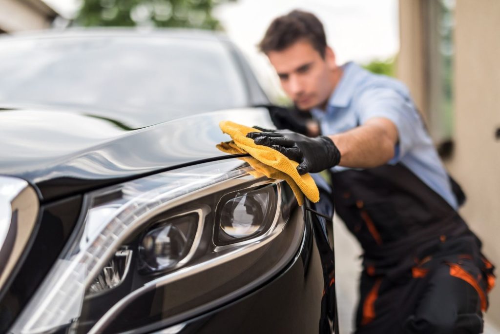 Expert hand dry car wash in Katy TX, ensuring a scratch-free finish on a luxury vehicle's hood.