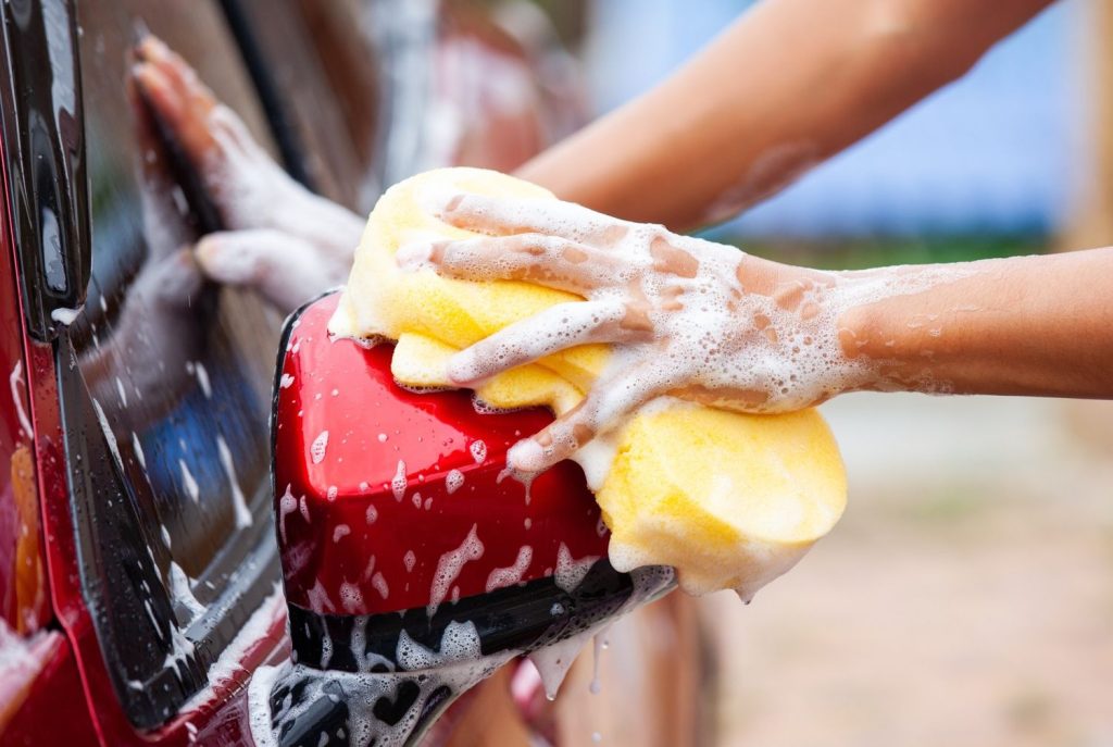 Personalized hand washing of tricky areas like side mirrors, a perk of a full-service car wash membership Katy TX.